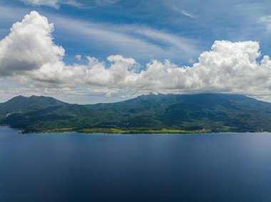 Derin mavi denizi olan tropik bir ada. Mavi gökyüzü ve bulutlar. Camiguin, Filipinler.