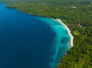 Beyaz kum ve mavi denizli sahil tatil köyünün insansız hava aracı manzarası. Samal Adası. Davao, Filipinler.