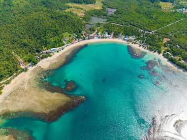 Tropik ada kıyı şeridindeki güzel beyaz kum. Turkuaz su ve bariyer resifleri. Mindanao, Filipinler. Seyahat kavramı.