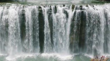 Tinuy an Falls 'daki su perdelerine yakın bambu saldaki insanların en üst hava görüntüsü. Mindanao, Filipinler. Yavaş Hareket.