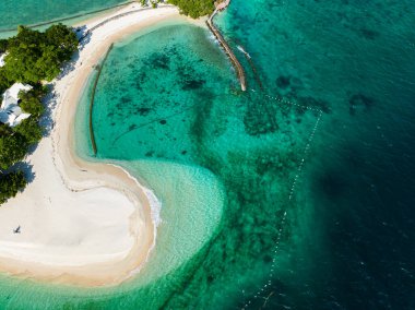 Kumsalda okyanus dalgaları. Şeffaf turkuaz su ve mercanlar. Samal, Davao. Filipinler.
