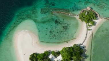 Turkuaz okyanus suyu ve dalgalı beyaz kumsal manzarası. Buenavista Adası. Samal, Davao. Filipinler.