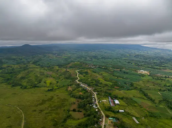 Yol boyunca büyüyen tarlaları ve küçük köyü olan dağ manzarası. Mindanao, Filipinler.