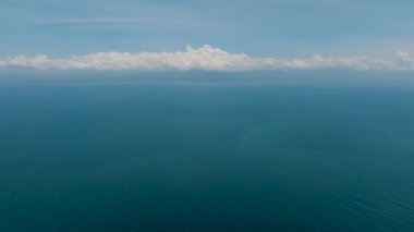 Mavi okyanuslu, mavi gökyüzü ve bulutlu deniz yüzeyi. Davao, Filipinler.