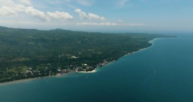 Ormanı ve yeşil bitki örtüsü olan tropik bir ada. Mavi gökyüzü ve bulutlar. Samal Adası. Davao, Filipinler.