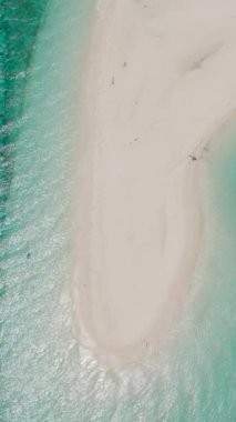 Tekneli ve dalgalı kum kayığı. Şeffaf turkuaz su. Mantigue Adası. Camiguin, Filipinler. Dikey video.