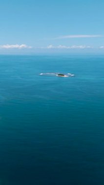 Beyaz plajlı mavi deniz. Mavi deniz ve bulutlu gökyüzü. Mindanao, Filipinler. Dikey görünüm.