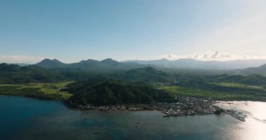 Güneş ışığı olan güzel sahil köyleri. Sahilde turkuaz su. Mindanao, Filipinler.