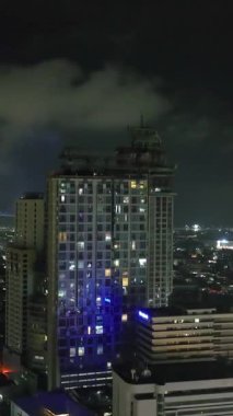 Renkli modern binalarla güzel bir gece sahnesi. Cebu, Filipinler. Dikey video. Dikey.
