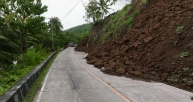 Şiddetli sağanak yağış nedeniyle toprak kaymaları dağ yolunu kapatıyor. Filipinler.