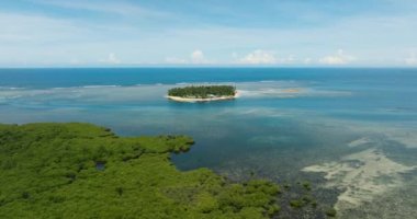 Turkuaz deniz suyuyla güzel bir tropikal ada. Mavi gökyüzü ve bulutlar. Mindanao, Filipinler. Seyahat kavramı.