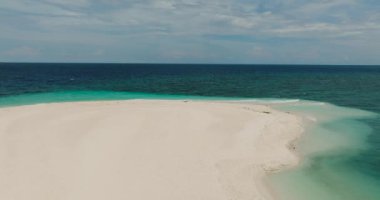Kıyı şeridine dalgalı dalgaların dokunduğu beyaz kumlu sahil. Beyaz Ada. Camiguin, Filipinler.