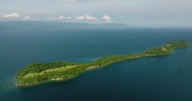 Yeşil ormanı ve kayalık kıyı şeridi olan tropik bir ada. Davao, Samal 'daki Ligid Adası. Filipinler.