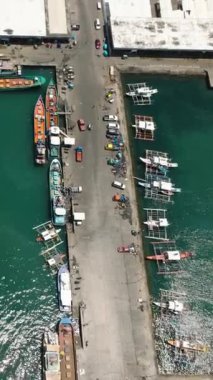 Balıkçı teknelerinin hava manzarası General Santos City Balık Limanı 'nın kenarında. Mindanao, Filipinler. Seyahat konsepti. Dikey görünüm.