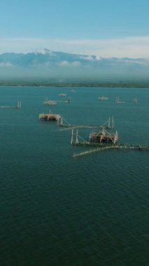 Lanao del Norte 'nin deniz yüzeyindeki balık çiftliğinin insansız hava aracı görüntüsü. Mindanao. Filipinler. Deniz Burnu. Dikey video.