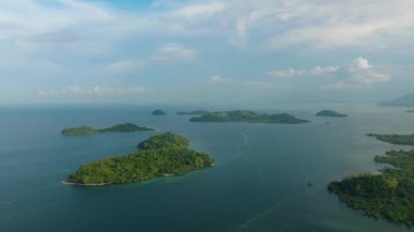 Mavi denizli ada kümesinin insansız hava aracı görüntüsü. Mavi gökyüzü ve bulutlar. Zamboanga, Filipinler.