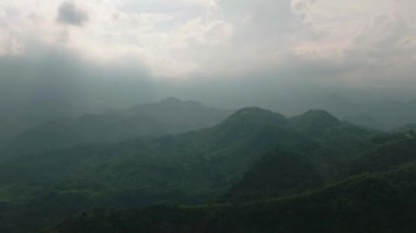 Yağmur ormanlı dağ yamaçları, kırsal alanda bulutlu gün batımı. Mindanao, Filipinler.