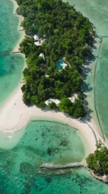 Güneş ışığı yansımalı mavi okyanus ve yukarıdan manzaralı beyaz sahil beldesi. Buenavista Adası. Samal, Davao. Filipinler. Dikey görünüm.