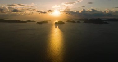 Turuncu gökyüzü ve adalar grubunun üzerindeki bulutlar. El Nido, Palawan 'da günbatımı. Filipinler.