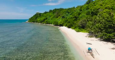 Turkuaz suyla kumlu sahildeki balıkçı teknesinin havadan görüntüsü. El Nido, Palawan 'daki Cagbuli Adası. Filipinler.