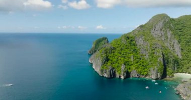 Mavi deniz ve tekneler, yukarıdan manzara. Güzel kireçtaşı kayaları olan bir ada. El Nido. Palawan, Filipinler.