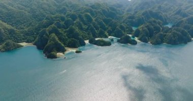 Mavi denizin üzerinde güneş yansıması. Kireçtaşı kayaları olan adalar. Kayangan Gölü. Barracuda Gölü. Coron, Palawan. Filipinler.