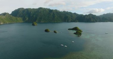 Mavi denizle çevrili tropikal adalar ve Islets tur botları. Mavi gökyüzü ve bulutlar. Coron, Palawan, Filipinler.