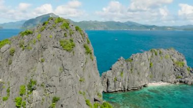 Miniloc Adası 'ndaki İkiz Kayalar' daki güzel kireçtaşı kayaları. Denizin üzerinde tekneler. El Nido, Filipinler. Palawan.