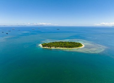 Beyaz kumlu plajlarla çevrili tropik bir ada. Gökyüzünün altında mavi deniz. Mindanao, Filipinler.