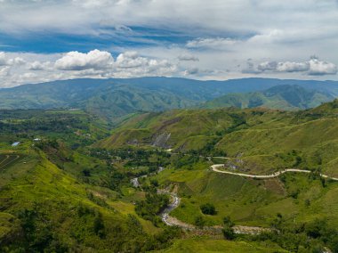 Nehrin üzerinde akan suyu olan yağmur ormanları. Asfalt yolu olan dağ vadisi. Mindanao, Filipinler.