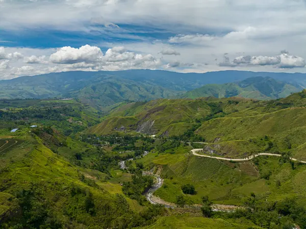 Nehrin üzerinde akan suyu olan yağmur ormanları. Asfalt yolu olan dağ vadisi. Mindanao, Filipinler.