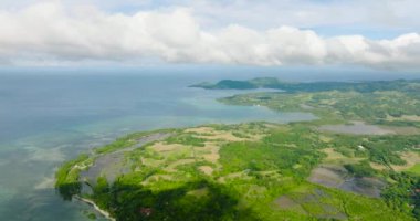 Tropik adanın kıyısındaki turkuaz deniz suyuyla birlikte tarım arazisinin havadan görünüşü. Tablolar Adası. Romblon, Filipinler.