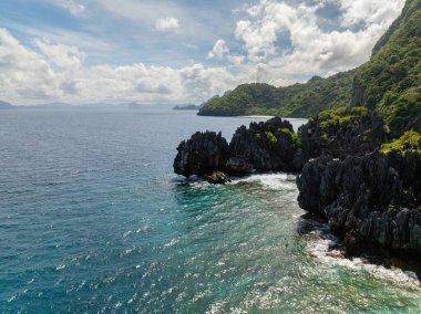Matinloc Adası 'ndaki kireçtaşı kayalarına deniz dalgaları çarpıyor. El Nido, Filipinler.