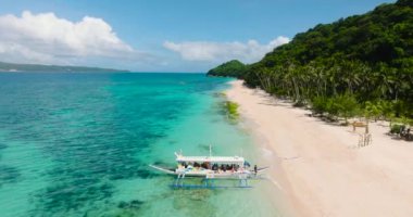 Puka Shell Sahili 'nde berrak sularda yüzen turist botu. Boracay Adası. Filipinler.