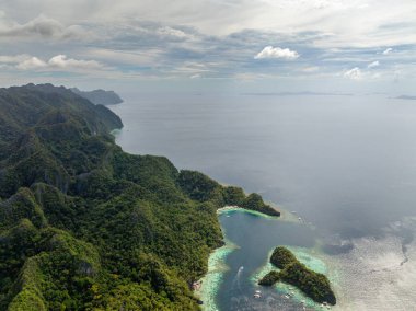 Koron, Palawan 'da Mavi Deniz' in üzerinde tekneler ve adacıklarla güneş yansıması. Filipinler.