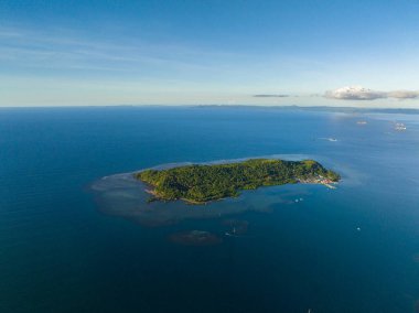 Tropik adanın kıyısındaki derin mavi denizli küçük köyün hava manzarası. Mindanao, Filipinler.
