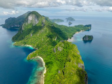 Plajları ve dağ ormanları olan Cadlao Adası. Filipinler 'de El Nido.