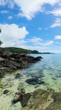 Romblon Adası 'ndaki kayalık sahilde açık yeşil deniz suyu. Filipinler. Dikey görünüm.