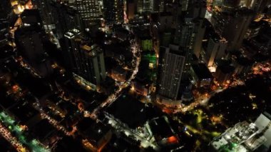 Modern binaların ve renkli sokakların üzerinde uçuyor. Geceleyin Makati City 'de. Metro Manila. Filipinler.