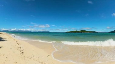 Güzel okyanus dalgaları kumlu sahilde kabarcıklar yaratır. Bon Bon Plajı. Romblon, Filipinler.