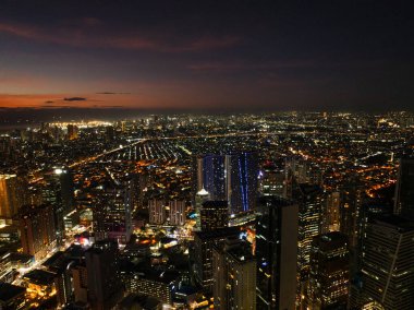 Otoyoldaki arabaların ve araçların gece görüşü. Makati Skyline. Metro Manila. Filipinler.