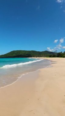 Kumsalda okyanus dalgaları, mavi gökyüzü ve bulutlar. Nacpan Sahili. El Nido. Palawan 'da. Filipinler. Dikey görünüm.