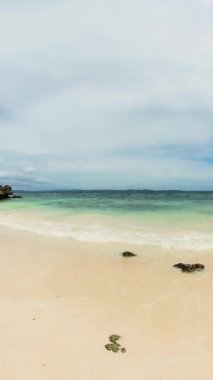 Filipinler, Romblon 'daki Carabao Adası' ndaki kumsalda dalgalar sıçrıyor. Dikey görünüm.