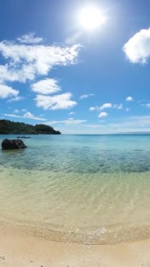 Kumlu sahil şeridi ve kristal berrak deniz suyu ve dalgaları. Tiamban Sahili. Romblon Adası. Filipinler. Dikey görünüm.
