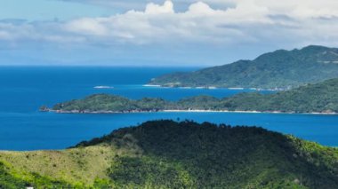 Mavi deniz ve sahil şeridinde kumlu plajları olan tropikal ada. Filipinler.