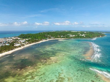 Boracay, Filipinler 'deki okyanus dalgaları ve modern binalarla beyaz kumlu plajların insansız hava aracı görüntüsü.