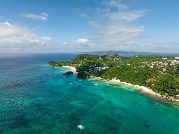Mavi gökyüzü ve bulutların altında tekneleri olan berrak sakin deniz suyu. Boracay, Filipinler plajları.