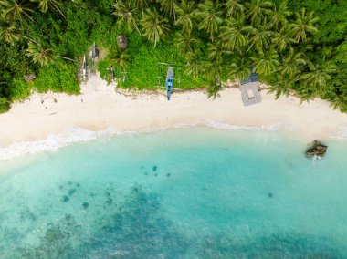 Kumsal manzarası, kumdaki teknelerin üzerine güneş yansıması ve turkuaz deniz dalgaları. Carabao Adası, Romblon. Filipinler.