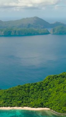 Beyaz kumlu sahili olan helikopter adası. Turkuaz deniz suyunun üzerinde tekneler. El Nido. Palawan, Filipinler. Dikey görünüm.