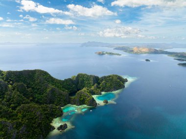 Coron 'da gölleri ve plajları olan adalar. Mavi deniz, mavi gökyüzü ve bulutlar. Palawan 'da. Filipinler.